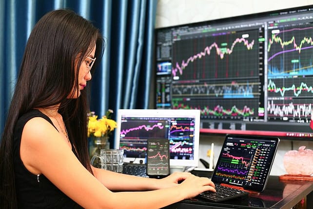 stock broker trading in front of computer screens