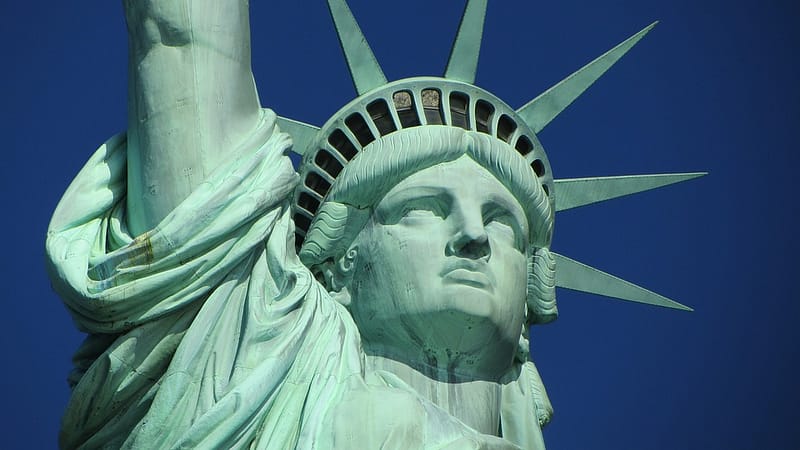 the statue of liberty on a blue sky background, representing the us stock market