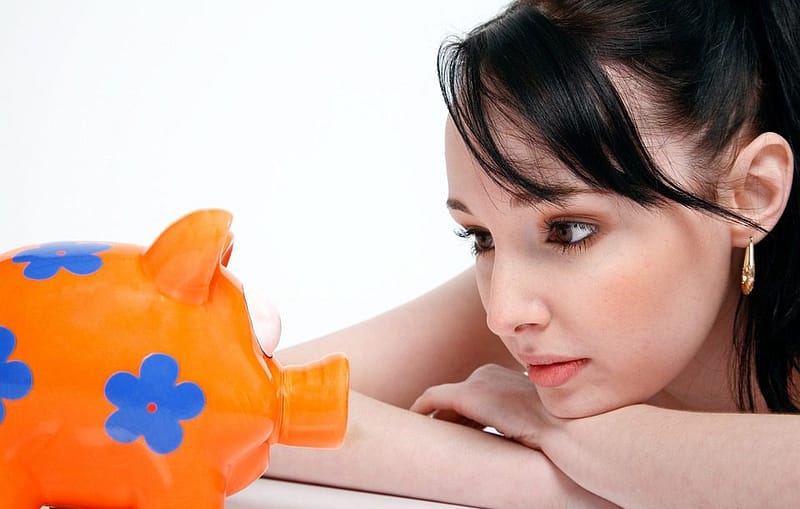 woman looking a piggy bank, saving on investing feed
