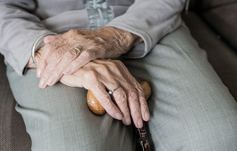 a senior retiree's hands on their lap