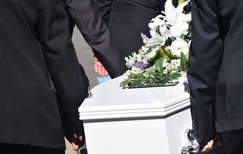 people carrying a white casket