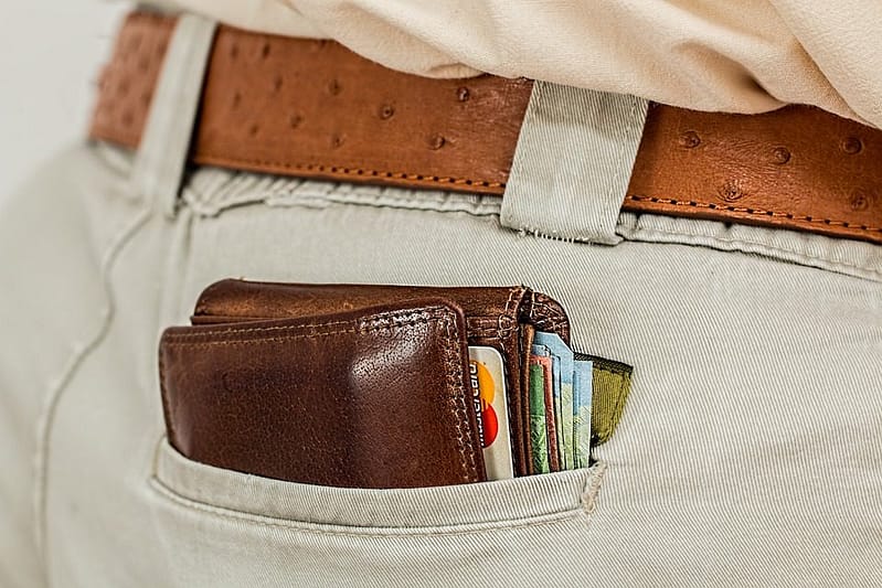 credit cards and cash in a wallet in the back pocket of a trouser