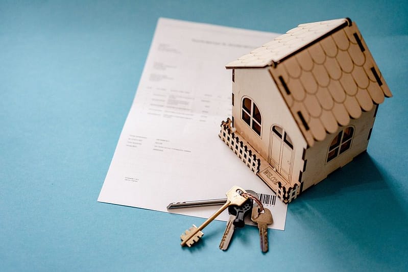 keys and a model house on a paper mortgage on a table