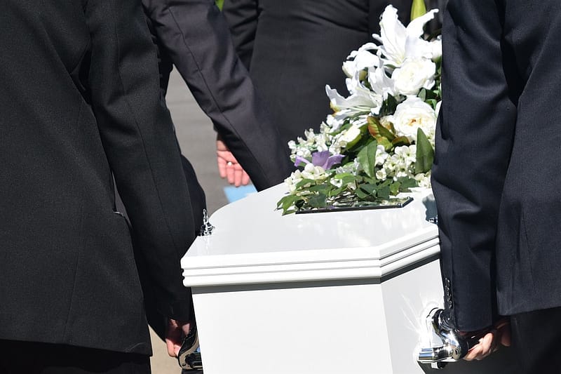 people carrying a white casket