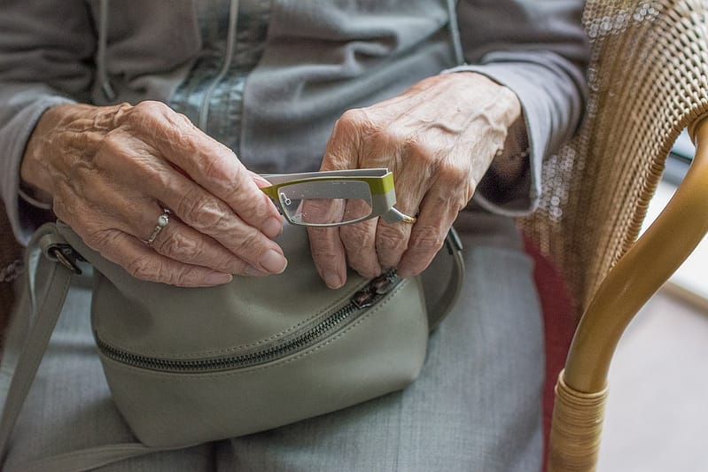 Elderly BC person on welfare taking glasses out of her purse