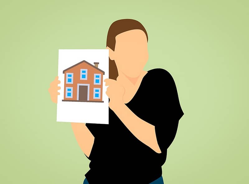 first time home buyer holding a picture of their home